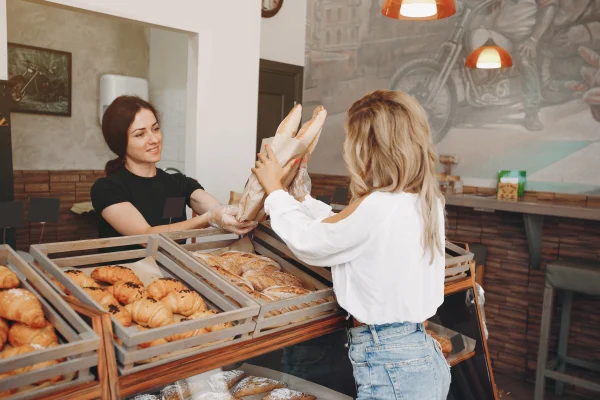 woman buys baguettes in a bakery